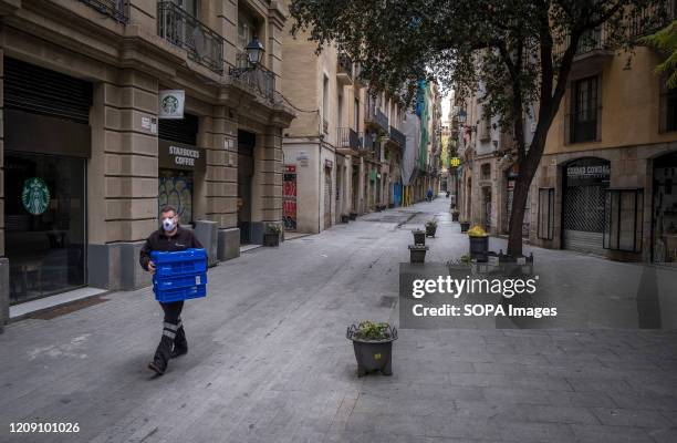 Pharmacy delivery man wearing a protective mask walks along a deserted street during the 19th day of home confinement and social distancing in...