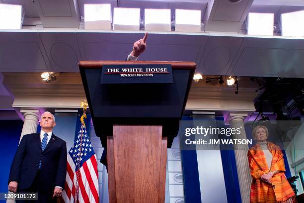 President Donald Trump gestures over the lectern as he speaks, flanked by Health and Human Services Secretary Alex Azar, US Vice President Mike Pence...