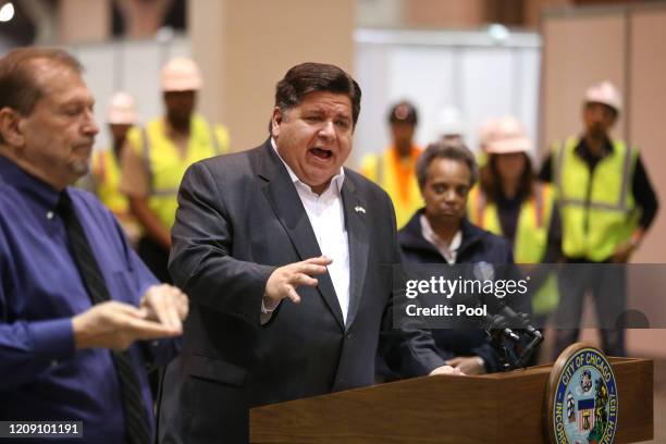 Chicago Mayor Lori Lightfoot stands by as Illinois Gov. J.B. Pritzker speaks during a press conference in Hall C Unit 1 of the COVID-19 alternate...