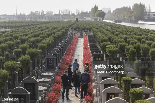 Visitors wearing protective masks gather in a public cemetery during the Qingming Festival in Shanghai, China, on Saturday, April 4, 2020....