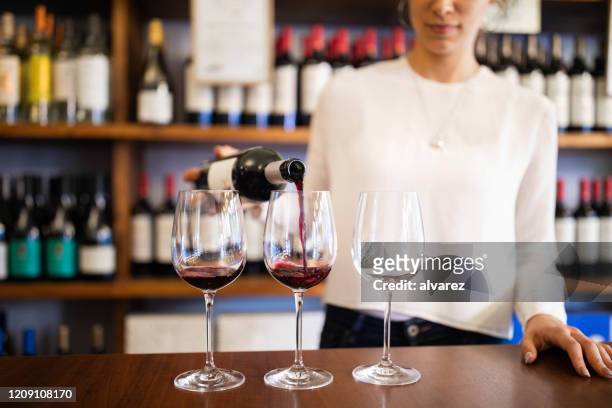 bartender serviert rotwein in einem weingut - sommelier stock-fotos und bilder