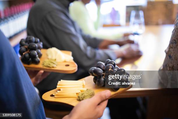 waiter with plates of cheese and grapes at winery. - wine close up stock pictures, royalty-free photos & images