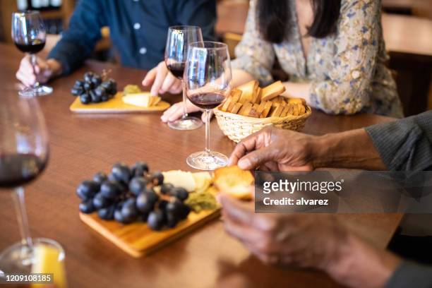 mat och dryck serveras på bord med människor på vinbar - cheese and wine bildbanksfoton och bilder