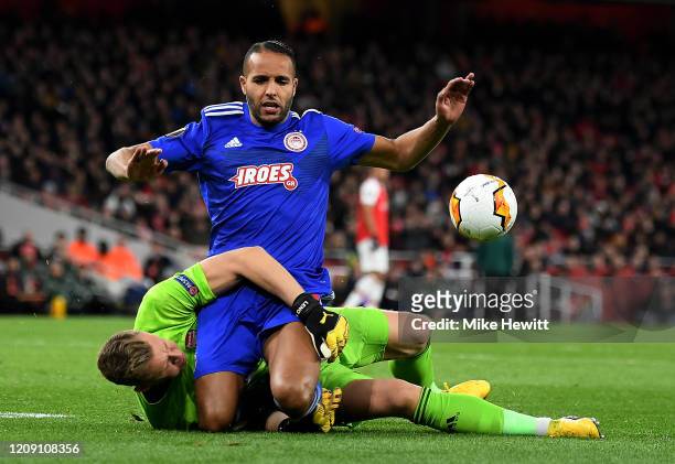 Youssef El Arabi of Olympiacos FC is tackled by Bernd Leno of Arsenal FC during the UEFA Europa League round of 32 second leg match between Arsenal...