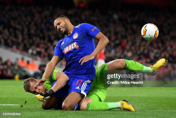 Youssef El Arabi of Olympiacos FC is tackled by Bernd Leno of Arsenal FC during the UEFA Europa League round of 32 second leg match between Arsenal...