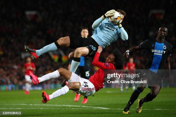 Tahith Chong of Manchester United collides with Simon Mignolet of Club Brugge during the UEFA Europa League round of 32 second leg match between...