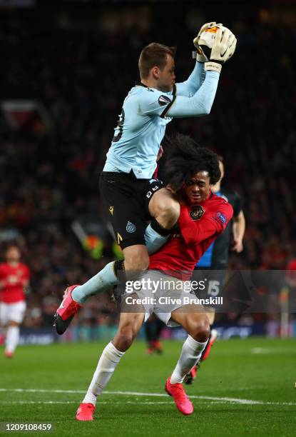 Tahith Chong of Manchester United collides with Simon Mignolet of Club Brugge during the UEFA Europa League round of 32 second leg match between...