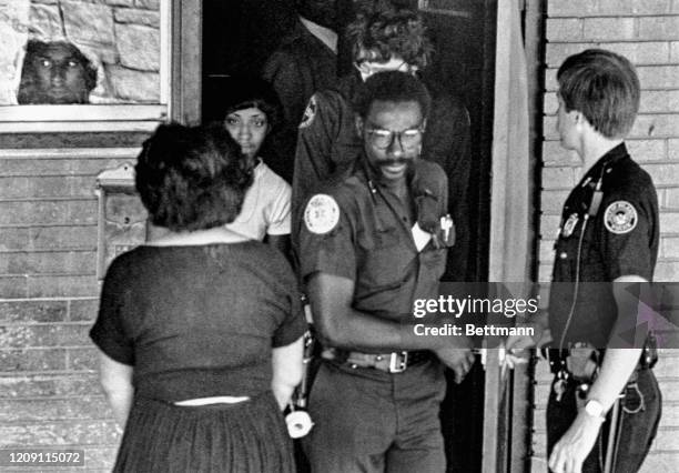 Youth watches from the window as friends and police file in and out of the home of Timothy Hill, whose mud covered body was pulled from the...