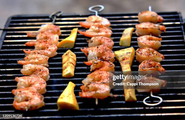 shrimp skewers cooking on grill with vegetables - bbq shrimp stock pictures, royalty-free photos & images