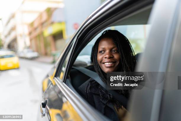 young woman sitting in car and looking through window from back seat - winter car window stock pictures, royalty-free photos & images