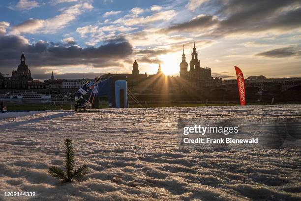 Woman racing at the Paralympic Ski World Cup on the banks of the river Elbe, the skyline of the baroque town in the distance.