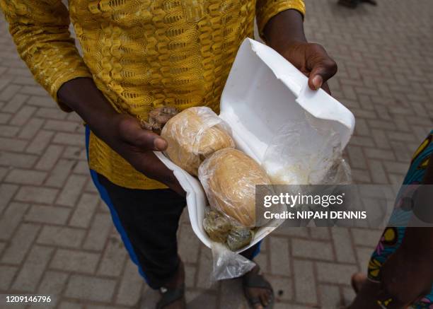 Boy holds a food parcels received at a food distribution organized by the government to help residents to cope with the lockdown at the Agbogbloshie...