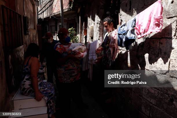 Volunteers deliver packs of food to residents in Jardim do Vale das Virtudes Favela at Campo Limpo neighborhood on April 4, 2020 in Sao Paulo,...