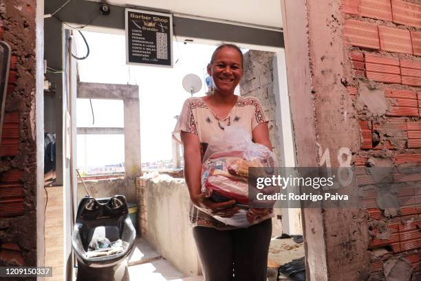 Resident of Jardim do Vale das Virtudes Favela receives a pack of food at Campo Limpo neighborhood on April 4, 2020 in Sao Paulo, Brazil. According...