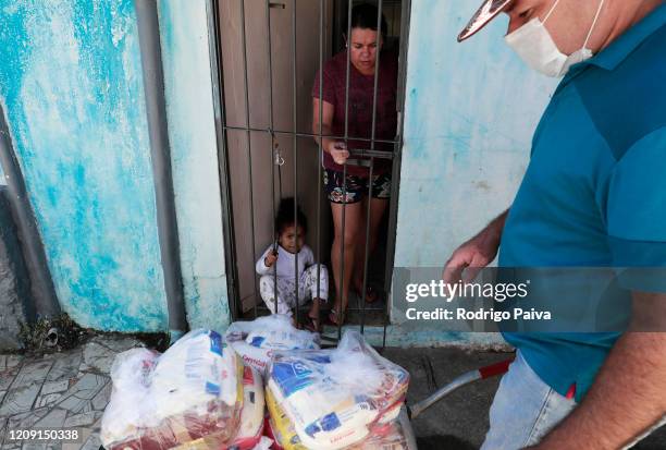 Volunteer delivers packs of food to residents of Jardim do Vale das Virtudes Favela at Campo Limpo neighborhood on April 4, 2020 in Sao Paulo,...
