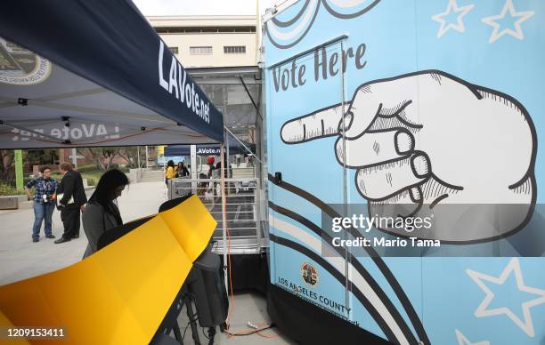 Voter prepares her ballot in a voting booth during early voting for the California presidential primary election at a new L.A. County ‘Mobile Vote...