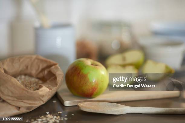 freshly cut apple, oats and cooking utensils in zero waste kitchen. - apple crumble stock pictures, royalty-free photos & images