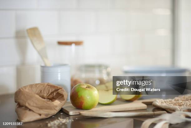 freshly cut apple, cooking oats and wooden utensils in zero waste kitchen. - apple crumble stock pictures, royalty-free photos & images