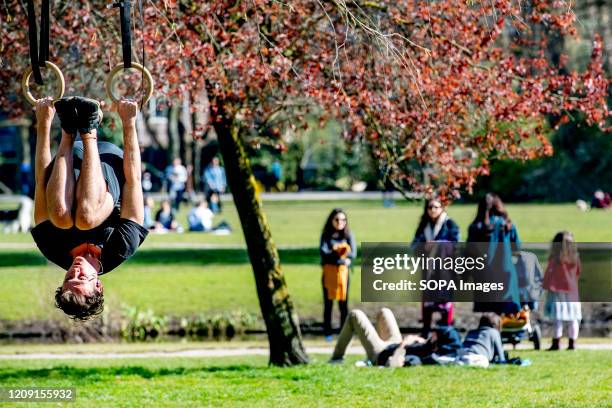 People enjoy the sun during a spring day at the Vondelpark in Amsterdam. The Dutch government ordered closure of public facilities and advised people...