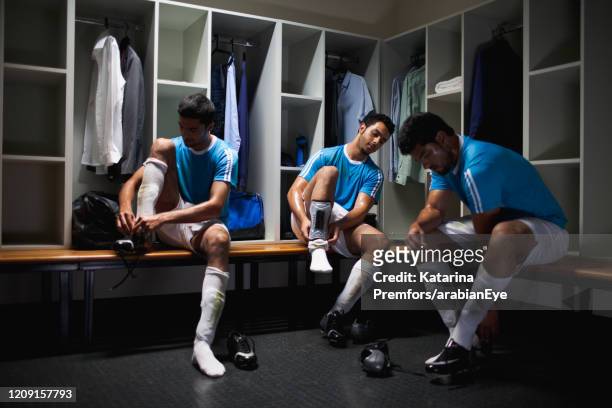 football players getting ready in locker room. - 更衣室 ストックフォトと画像