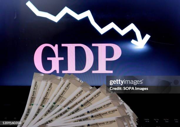 In this photo illustration Five hundred Rupee notes are seen on display with a GDP bar chart on the background.