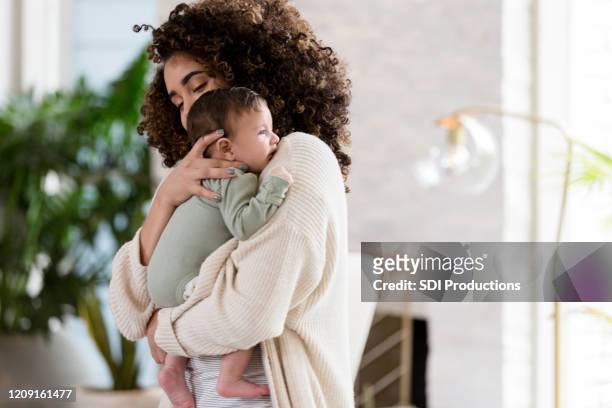 mom comforts fussy baby - baby stock pictures, royalty-free photos & images