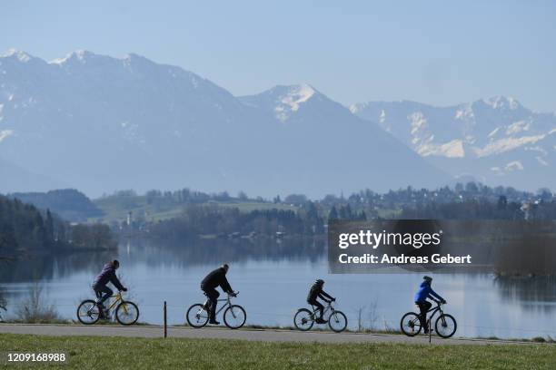 Cyclists pass Lake Riegsee while restrictions continue in an effort to rein in the spread of the coronavirus, on April 5, 2020 near Murnau, Germany....