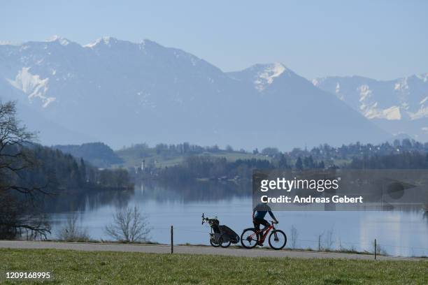 Cyclist passes Lake Riegsee while restrictions continue in an effort to rein in the spread of the coronavirus, on April 5, 2020 near Murnau, Germany....