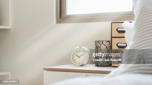alarm clock shows eight o'clock, standing on night table at sleeping room. - awake day stock-fotos und bilder