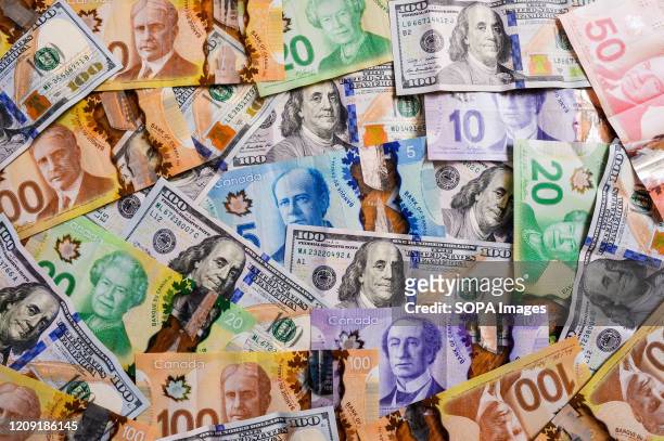 In this photo illustration US Dollar and Canadian Dollar banknotes.