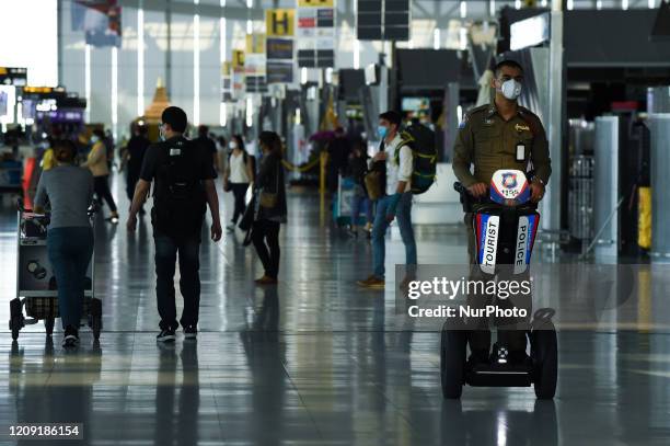 Thai police officers patrol the airport after several airlines suspended their flight operations, at Suvarnabhumi Airport, Samut Prakan province,...