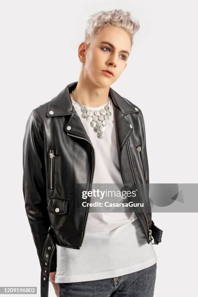 fashionable boy in his late teens posing with hands behind his back against white background - stock photo - androgynous boys stock pictures, royalty-free photos & images