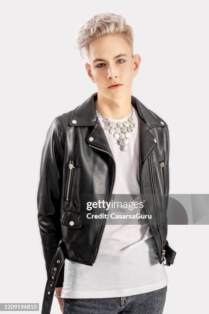 gender fluid teenager in leather jacket standing against white background - stock photo - androgynous boys stock pictures, royalty-free photos & images