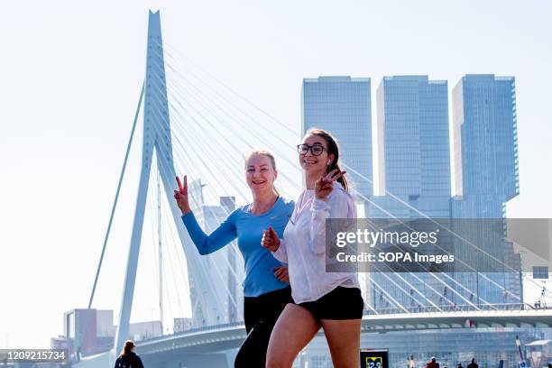 Women gesture while jogging on the Rotterdam Marathon course during the corona virus crisis. The Rotterdam Marathon is always carried out on the 5th...