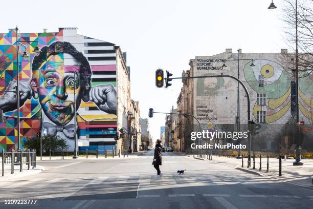 Woman is seen walking a dog on a street as Polish government introduced strict regulations to tackle the spread of Coronavirus pandemic - Lodz,...