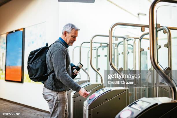 hombre de pelo gris maduro que conmuta y usa el pago sin contacto para comprar el boleto - trein nederland fotografías e imágenes de stock