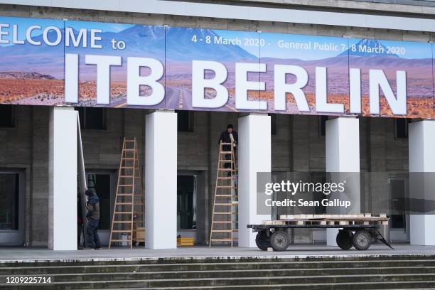 Workers prepare the main entrance of the Messe Berlin trade fair halls ahead of the upcoming ITB tourism trade fair on February 28, 2020 in Berlin,...