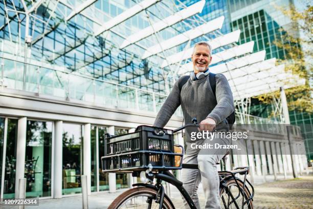 volwassen grijs haar man fietsen en draagt bij aan eco-vriendelijke omgeving - netherlands stockfoto's en -beelden