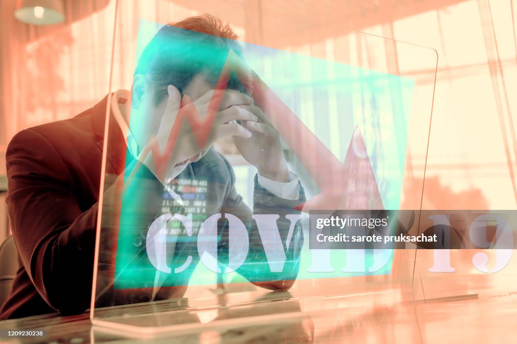 Concept of financial problems. Man holding his head while the markets plunge serious Covid-19 ,corona virus effect health investment .