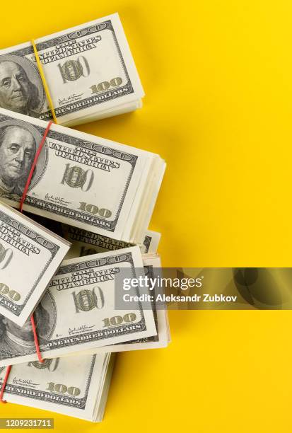 us dollars american bills in bundles on a bright yellow background. - american one hundred dollar bill stockfoto's en -beelden