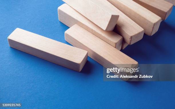 a pile of scattered wooden blocks on a blue background. construction game. the broken tower. - block removal game stock pictures, royalty-free photos & images