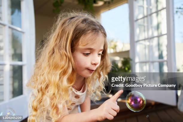 cute little girl smiling and popping soap bubbles outside - catching bubbles stock pictures, royalty-free photos & images