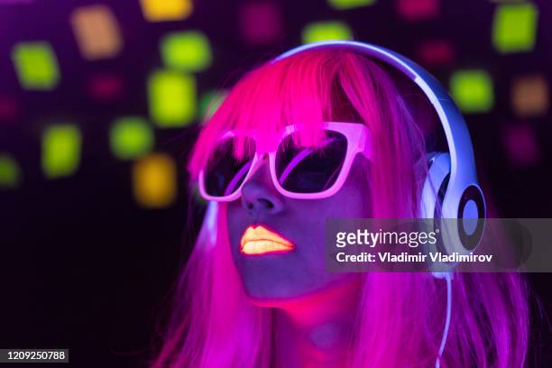 woman with pink colored hair and sunglasses listening music - neon fluorescent hair stock pictures, royalty-free photos & images