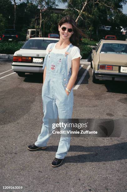 American actress Lori Loughlin wearing sunglasses and denim dungarees over a white t-shirt, with her hands her pockets, at the Starlight Foundation...