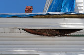 Underside of fascia on a house with wood and insulation dropping through