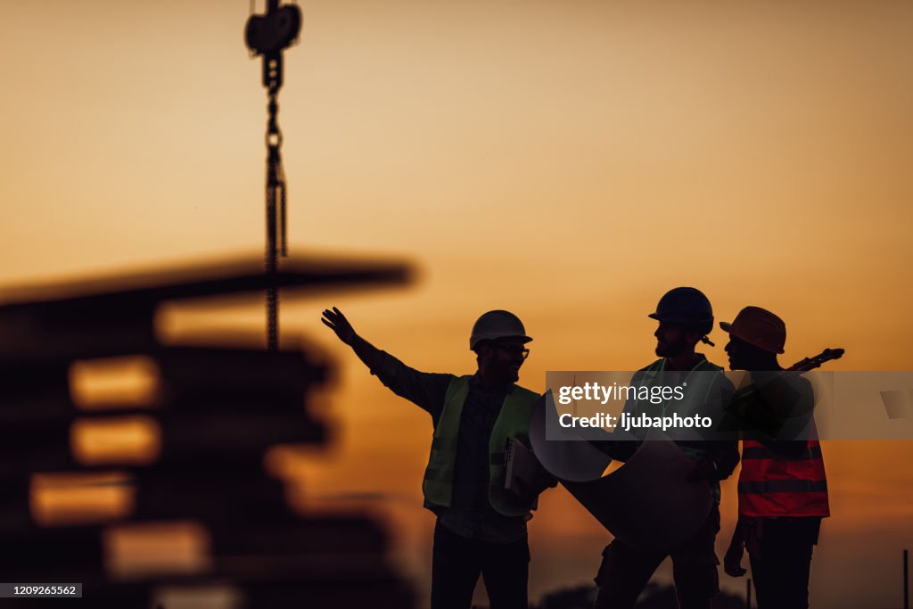 建設作業員が建築計画について話し合う