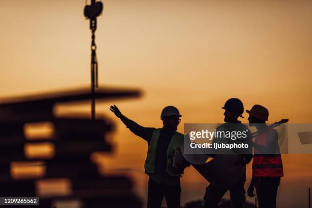 construction workers discuss the building plans - segurança no trabalho imagens e fotografias de stock