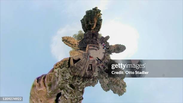 giant stone face tower of bayon temple with little planet format - angkor thom fotografías e imágenes de stock