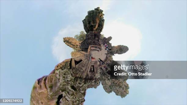 giant stone face tower of bayon temple with little planet format - bayontempel stockfoto's en -beelden