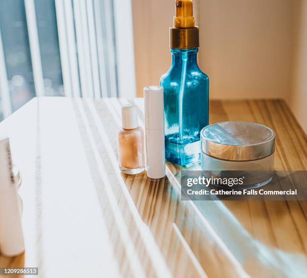 cosmetics on a table - bolsa de cor creme fotografías e imágenes de stock
